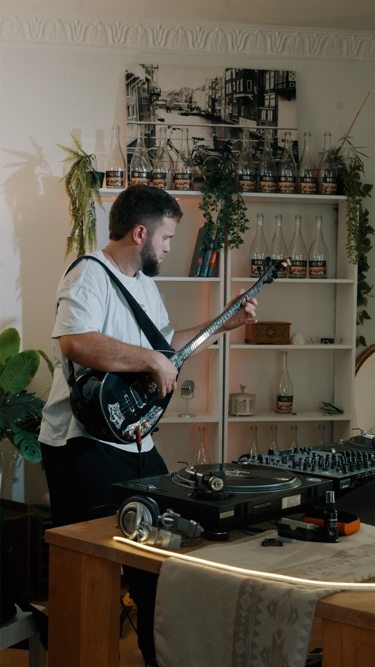 Sergjio spielt die Elektro-Saz neben dem DJ-Pult, von der Seite gesehen