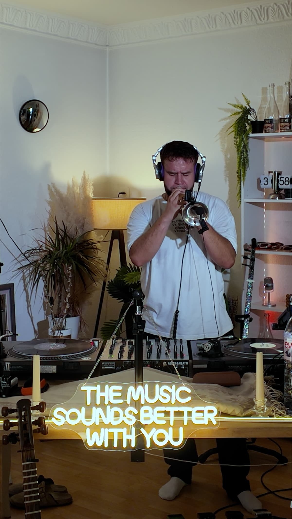 Sergjio spielt mit Kopfhörern Cornet hinter den Plattenspielern